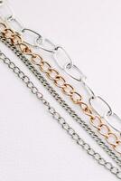 oro y plata joyería cadenas de diferente diámetros en un blanco antecedentes. foto