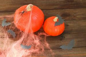 calabaza con arañas y telarañas en un de madera mesa, Víspera de Todos los Santos concepto foto