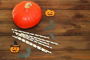 Pumpkin with bats and cocktail sticks on a wooden table, Halloween concept photo