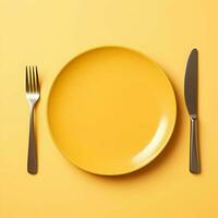 Minimalistic yellow ceramic plate with metallic fork and knife on yellow background. High resolution. AI Generative photo