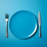 Blue ceramic plate with fork and knife lying next to on blue background. High resolution. AI Generative photo