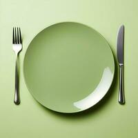 Minimalistic green ceramic plate with metal fork and knife. Top view. Highresolution. Ai generative photo