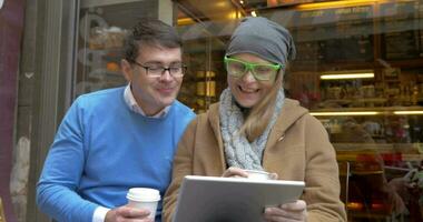Jeune couple ayant café et en utilisant tampon dans ville video