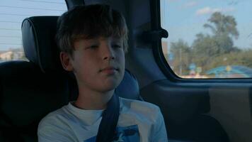 Boy with fastened seat belt traveling by car video