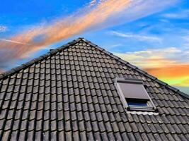 Open roof window in velux style with black roof tiles. photo