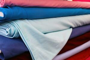 Detailed close up view on samples of cloth and fabrics in different colors found at a fabrics market photo