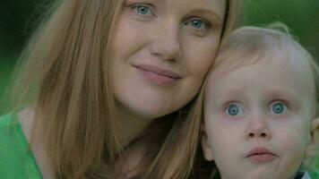 Young mother and lovely little son, outdoor portrait video