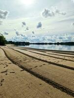 A beach at a lake with a strange pattern in the sand. photo