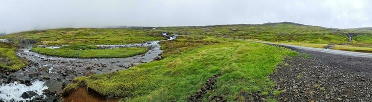 Icelandic landscape with flowing rivers surrounded by rocks and grass. photo