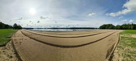 A beach at a lake with a strange pattern in the sand. photo