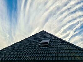 Open roof window in velux style with black roof tiles. photo