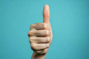 Close up of womans hand gives a positive thumbs up on blue AI Generated photo