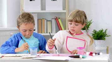 zwei Kinder sind Gemälde beim ein Tabelle video