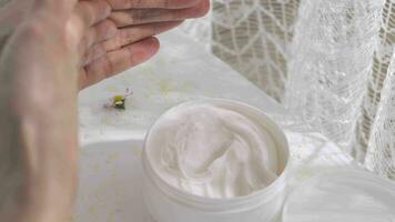 une blanc récipient de crème sur une table avec fleurs video