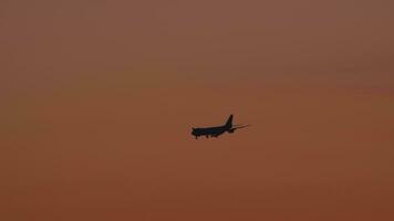 fuselaje ancho avión de carga en el final Acercarse antes de aterrizaje en el antecedentes de el puesta de sol oscuridad cielo video