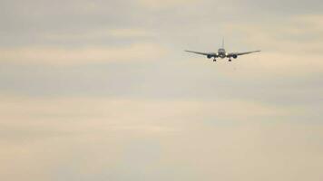 Jet plane approaching landing in the sunset sky, view from below. Passenger flight arrival video