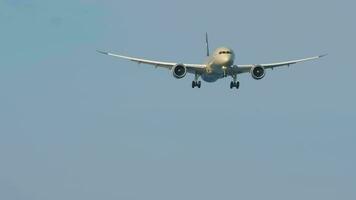 Civil airliner approaching for landing. Airplane with unrecognizable livery descending in the blue sky. Aircraft flies video