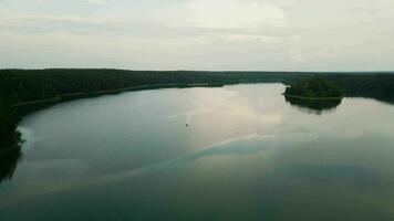 un solitario barco flotadores en el suave superficie de el lago. asveja es el mas largo lago en Lituania video