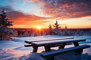 Snow covered wooden table at sunset in a wintry scene with an available seat photo