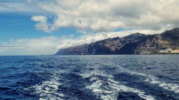The mighty cliffs of Los Gigantes of Tenerife viewed from a swaying boot. video
