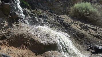 residuos agua fluye fuera de un aguas residuales tubo dentro un arenoso agujero. video