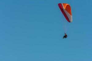 vistoso parapente volador con azul cielo foto