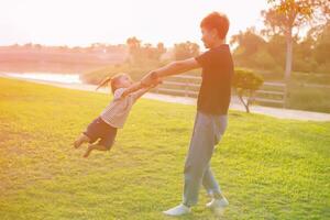 Happy harmonious family outdoors. mother throws baby up, laughing and playing in the summer on the nature.SSTKHome photo