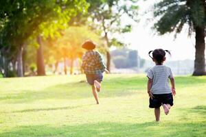 perfil ver de linda niños correr en parque sostener manos.sstkhome foto