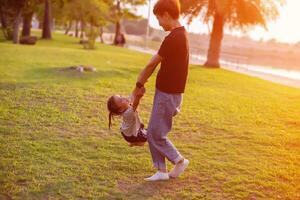 Happy harmonious family outdoors. mother throws baby up, laughing and playing in the summer on the nature.SSTKHome photo