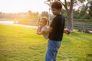 un silueta de un contento joven madre armonioso familia al aire libre. riendo y jugando en el verano en el puesta de sol fondo.sstkhome foto