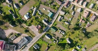 panorámico aéreo ver de eco pueblo con de madera casas, grava camino, jardines y huertos video