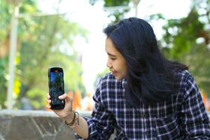 cheerful asian woman influencer recording holiday vlog in outdoor photo