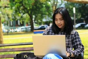 relax asian young woman smiling using laptop working freelance and happy get e commerce offer photo