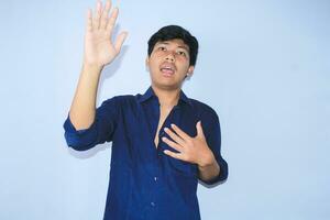 asian man is screaming and hold his chest after get painful heart attack with hands raised wear open navy shirt photo