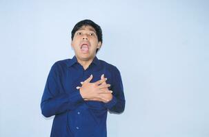 asian man office worker screaming and touching his chest suffering from heart attack pain wearing navy shirt, isolated white photo