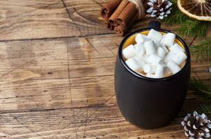 Hot chocolate with marshmallow cinnamon sticks, anise, nuts on wooden background, Christmas concept photo
