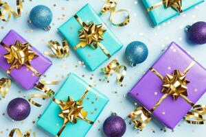 Flat lay background for celebration Christmas and New Year. Gift boxes are purple and turquoise with gold ribbons bows and confetti stars on a blue background. top view photo