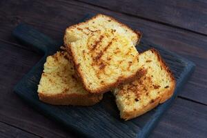 Slices toast wheat bread on a dark wooden background. Copy space. photo