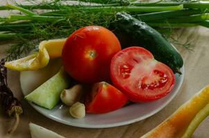 Vegetables and herbs, preparation for salad, are on a plate photo