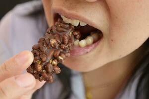 Close-up view of mouth eating food photo