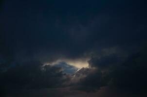 oscuro cielo con Brillo Solar mediante el nubes foto