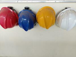 a group of hard hats hanging on a wall photo