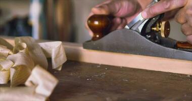 Master carpenter works with a hand plane on wood with thin shaving video