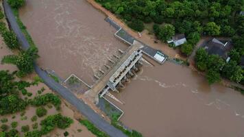 Aerial view of water released from the drainage channel of the concrete dam is a way of overflowing water in the rainy season. Top view of turbid brown forest water flows from a dam in Thailand. video