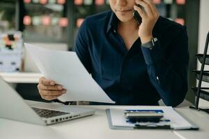 Young businessman working at office with laptop, tablet and taking notes on the paper. photo