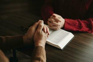 dos personas leyendo y estudiar Biblia en hogar y orar juntos.estudiando el palabra de Dios con amigos. en Dom ligero foto