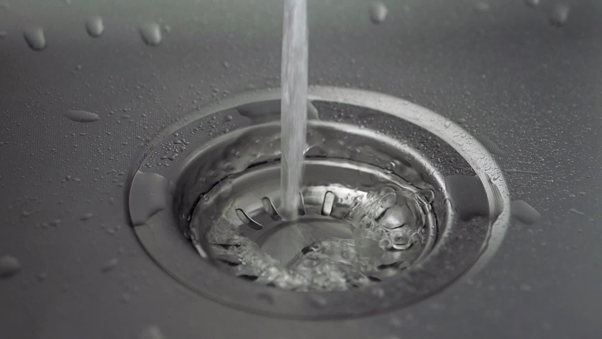 slow motion of water coming from running tap in stainless steel sink