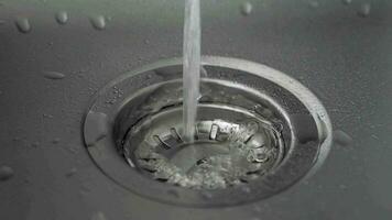 slow motion of water coming from running tap in stainless steel sink video