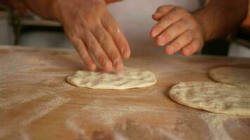 hands form pieces of dough for baking bread and rolls. video