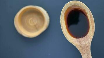 Soy Sauce on a wooden and spoon on black background video